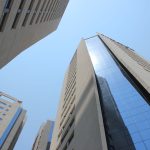 Edifícios modernos de Assunção vistos de baixo contra um céu azul.