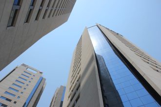 Edifícios modernos de Assunção vistos de baixo contra um céu azul.