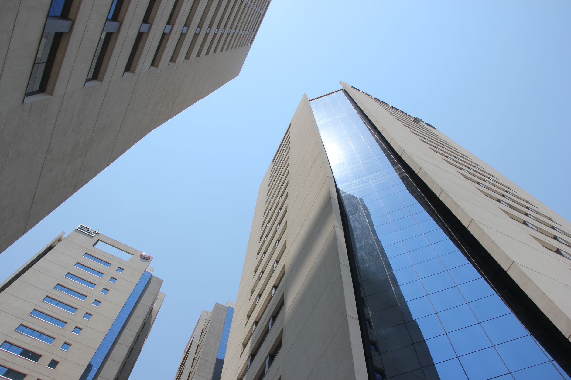 Edifícios modernos de Assunção vistos de baixo contra um céu azul.